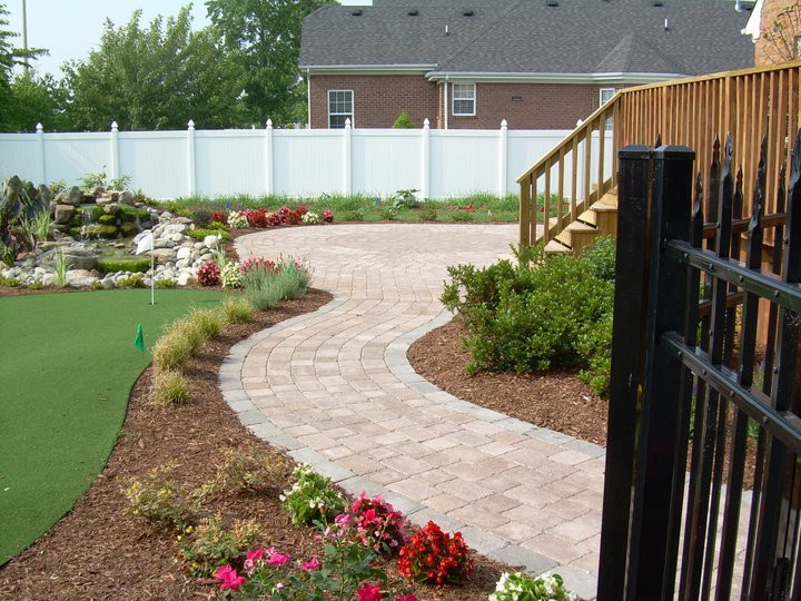 Idées déco pour un jardin arrière classique de taille moyenne avec un massif de fleurs, une exposition ensoleillée et un paillis.