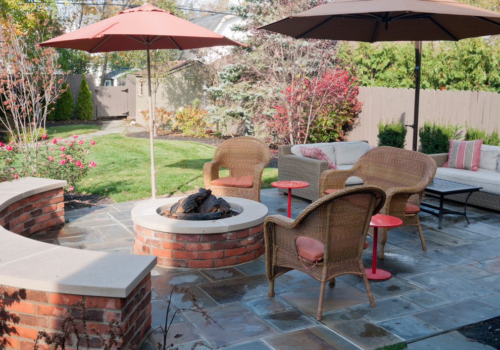 Ejemplo de patio clásico de tamaño medio en patio trasero con brasero y adoquines de piedra natural