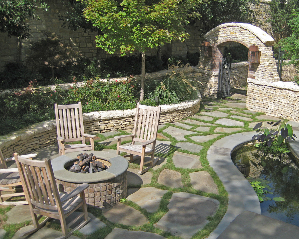 Cette image montre un jardin traditionnel avec un foyer extérieur.
