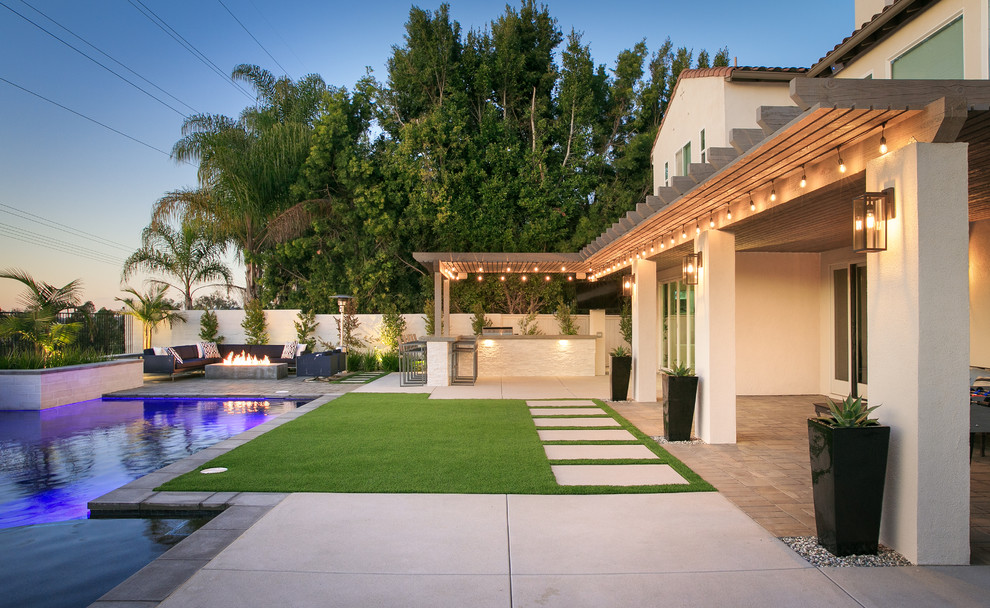 Mittelgroßer Moderner Garten hinter dem Haus, im Sommer mit Feuerstelle, direkter Sonneneinstrahlung, Betonboden und Metallzaun in San Diego