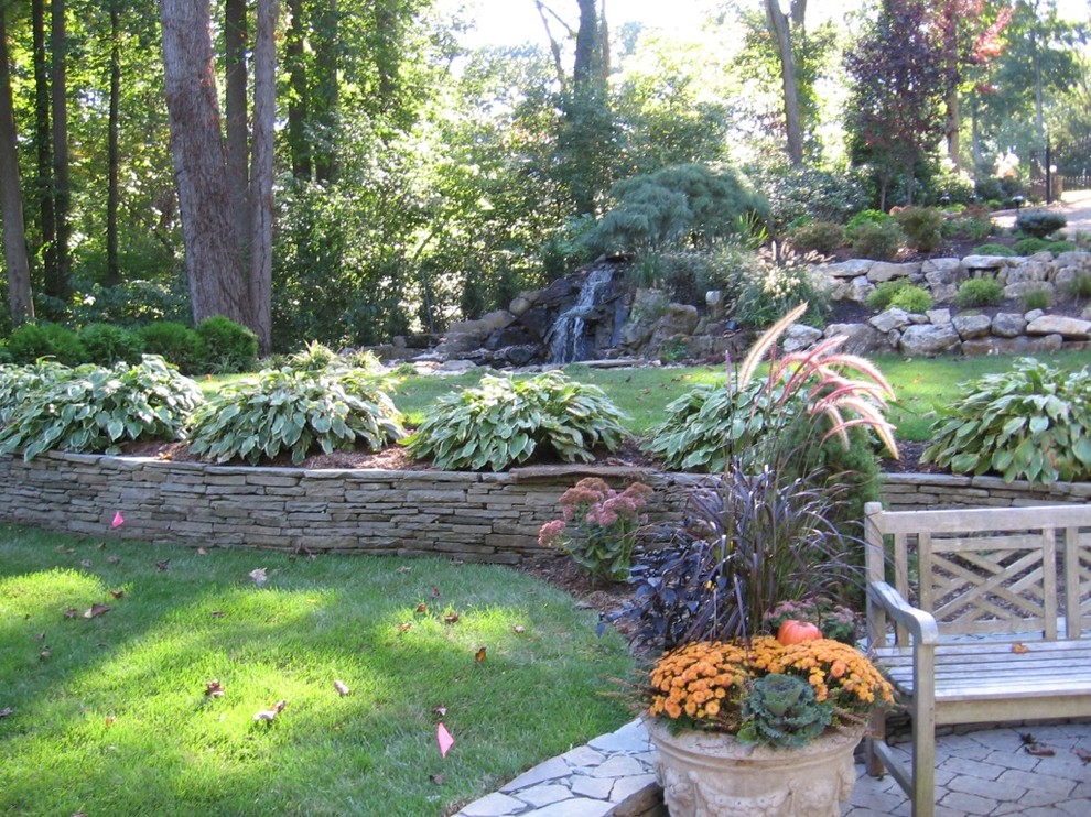 Exempel på en klassisk bakgård, med en trädgårdsgång och naturstensplattor