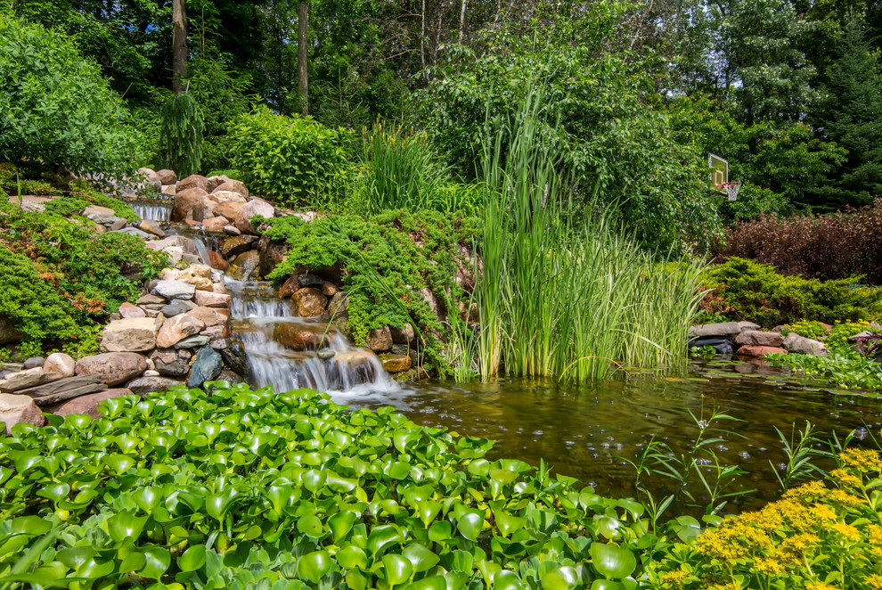 Exemple d'un grand jardin à la française arrière chic l'été avec un bassin, une exposition partiellement ombragée et des pavés en pierre naturelle.