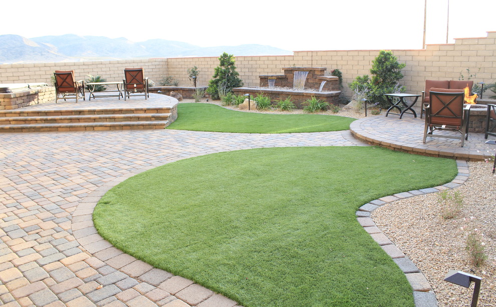 Inspiration for a mid-sized traditional drought-tolerant and full sun backyard concrete paver landscaping in Las Vegas with a fire pit.