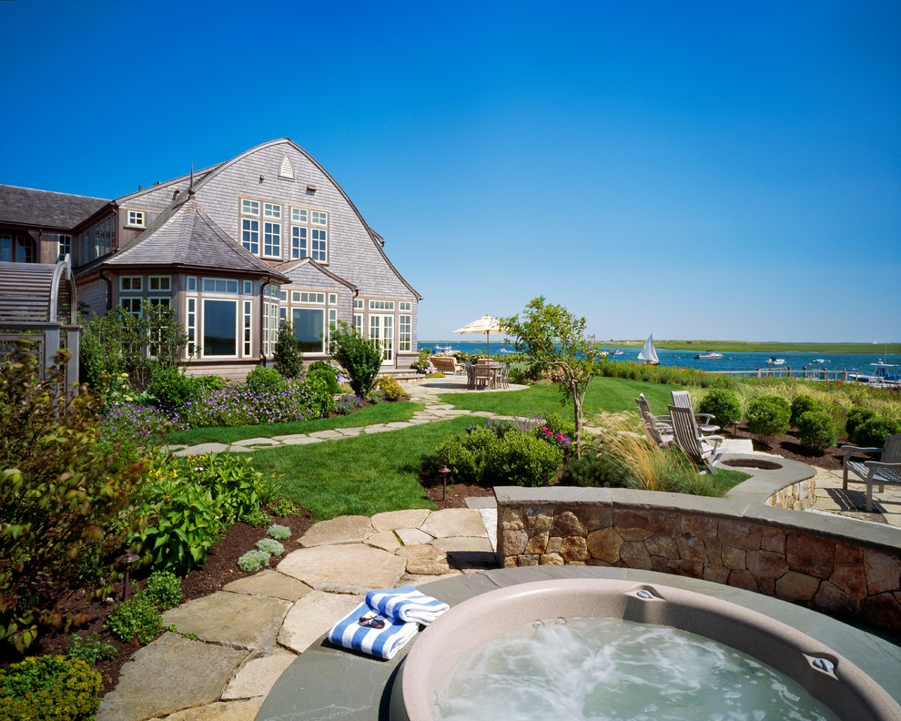 This is an example of an expansive classic back garden in Boston with natural stone paving.