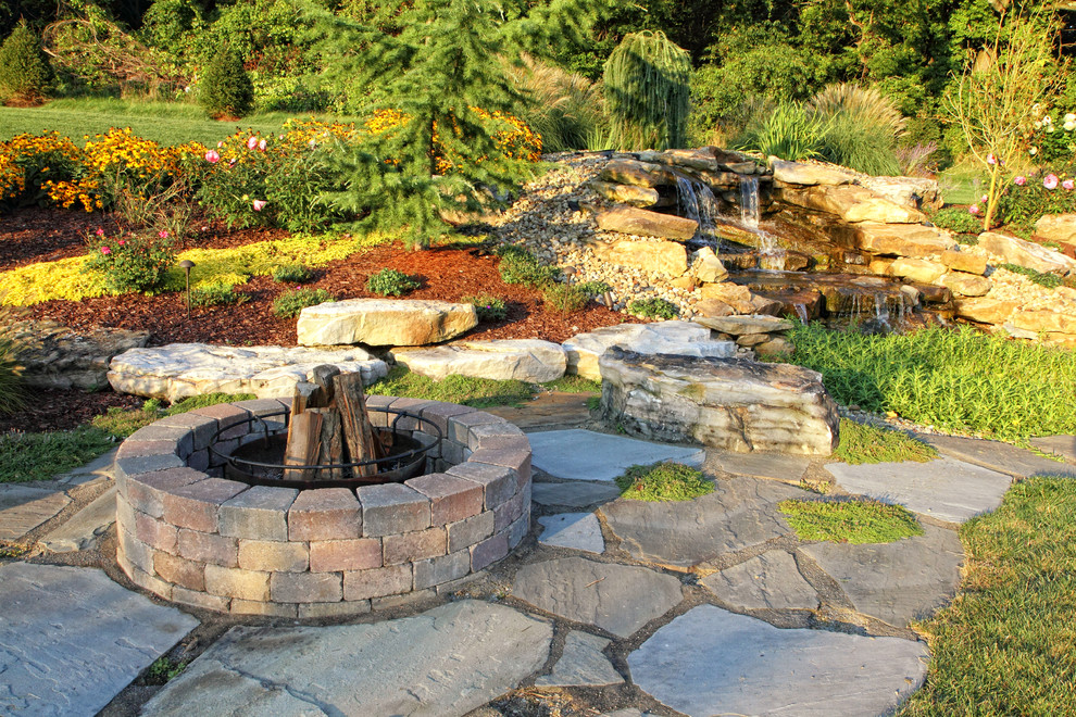 Imagen de jardín tradicional con adoquines de piedra natural y roca decorativa