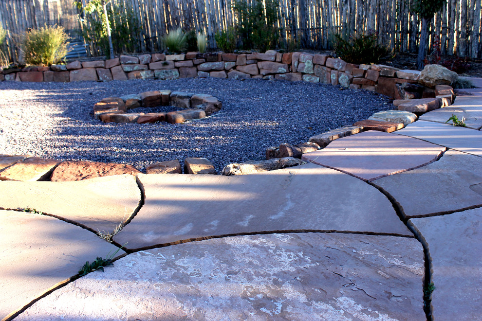 This is an example of a medium sized back xeriscape partial sun garden in Albuquerque with a fire feature and gravel.