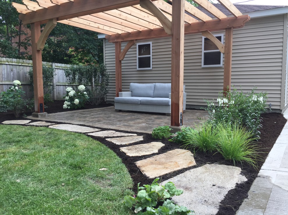 Ejemplo de jardín clásico renovado de tamaño medio en patio trasero con exposición total al sol y adoquines de piedra natural