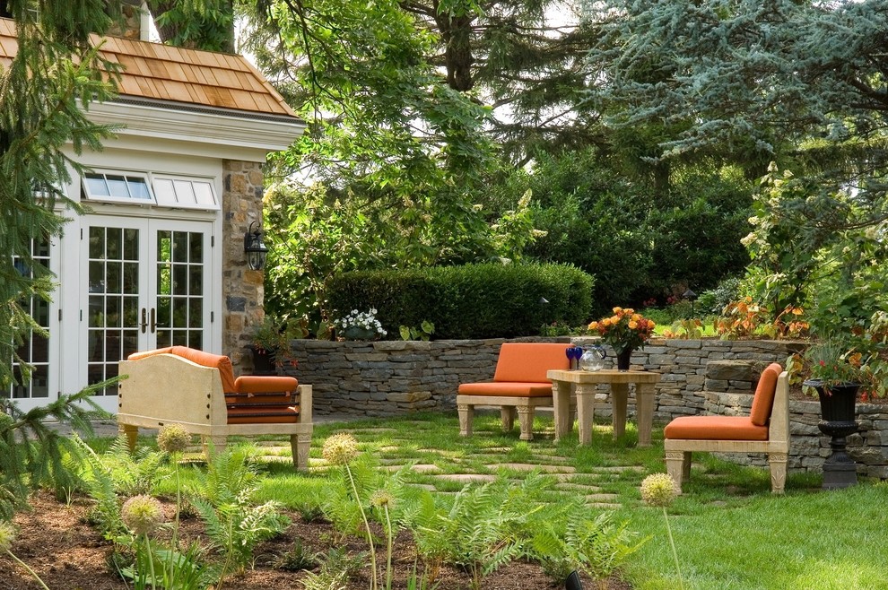 Cette photo montre un jardin à la française arrière chic de taille moyenne avec une exposition ombragée, un mur de soutènement et des pavés en pierre naturelle.
