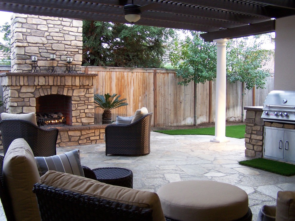 Ispirazione per un patio o portico stile americano di medie dimensioni e dietro casa con un focolare e pavimentazioni in pietra naturale