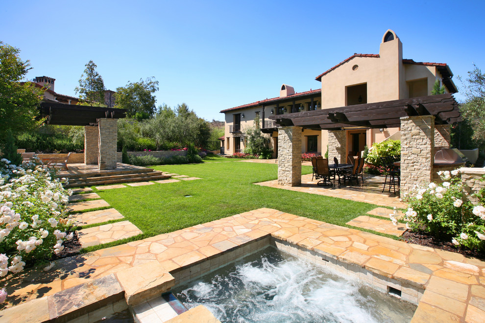 Design ideas for a traditional backyard stone landscaping in Orange County.