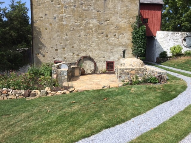 Imagen de jardín tradicional grande en patio trasero con brasero, exposición total al sol y adoquines de piedra natural