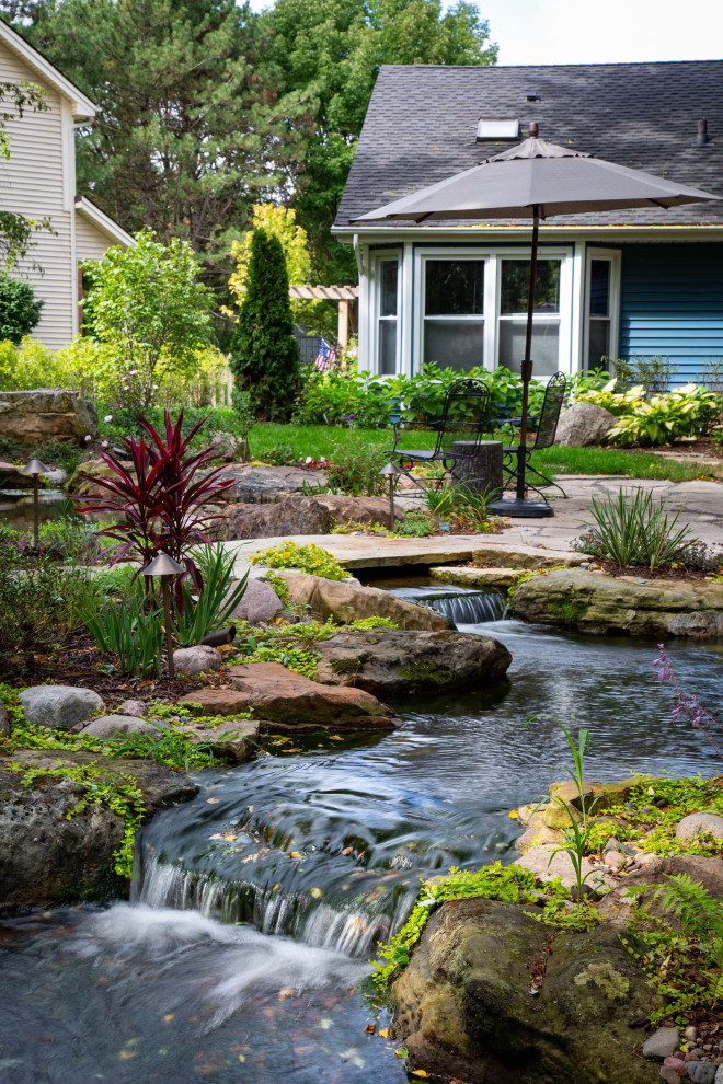 Immagine di un ampio giardino classico esposto a mezz'ombra dietro casa in primavera con pavimentazioni in pietra naturale