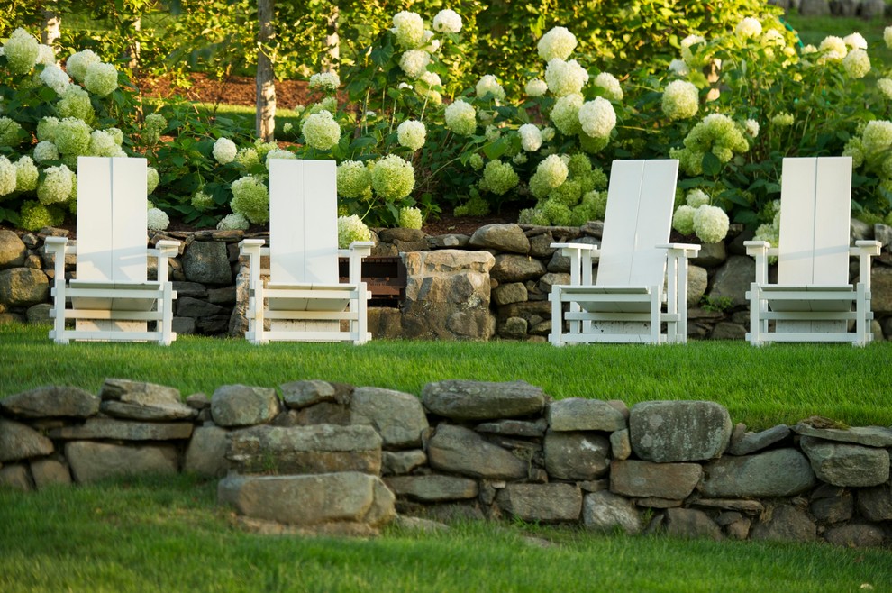 На фото: летний регулярный сад среднего размера на склоне в классическом стиле с подпорной стенкой и полуденной тенью