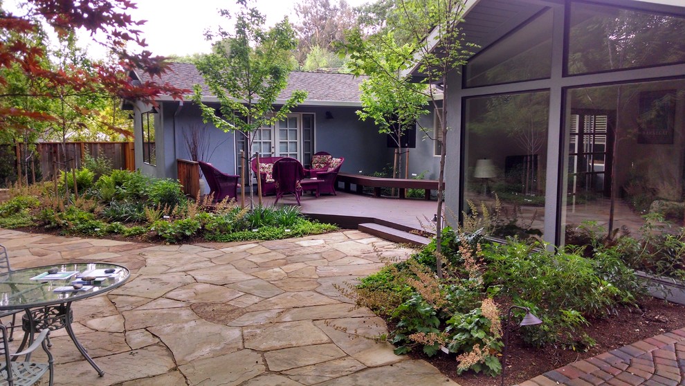 На фото: большой тенистый, весенний участок и сад на заднем дворе в стиле неоклассика (современная классика) с настилом и местом для костра с