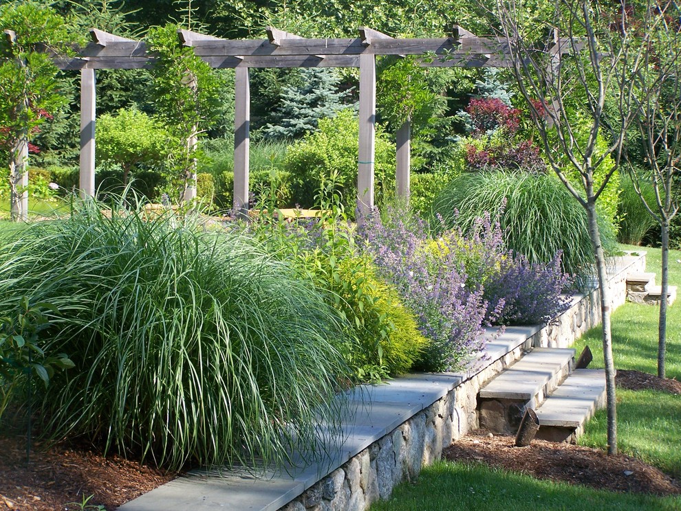 Ejemplo de jardín clásico grande en verano en patio trasero con jardín de macetas, exposición parcial al sol y adoquines de piedra natural