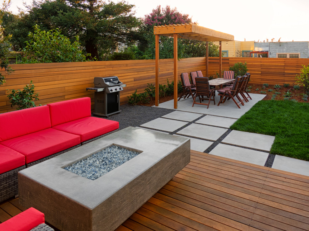 Идея дизайна: маленький солнечный регулярный сад на заднем дворе в стиле модернизм с местом для костра, хорошей освещенностью и настилом для на участке и в саду
