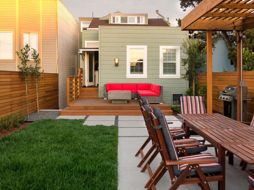This is an example of a small modern full sun backyard formal garden in San Francisco with a fire pit and decking.
