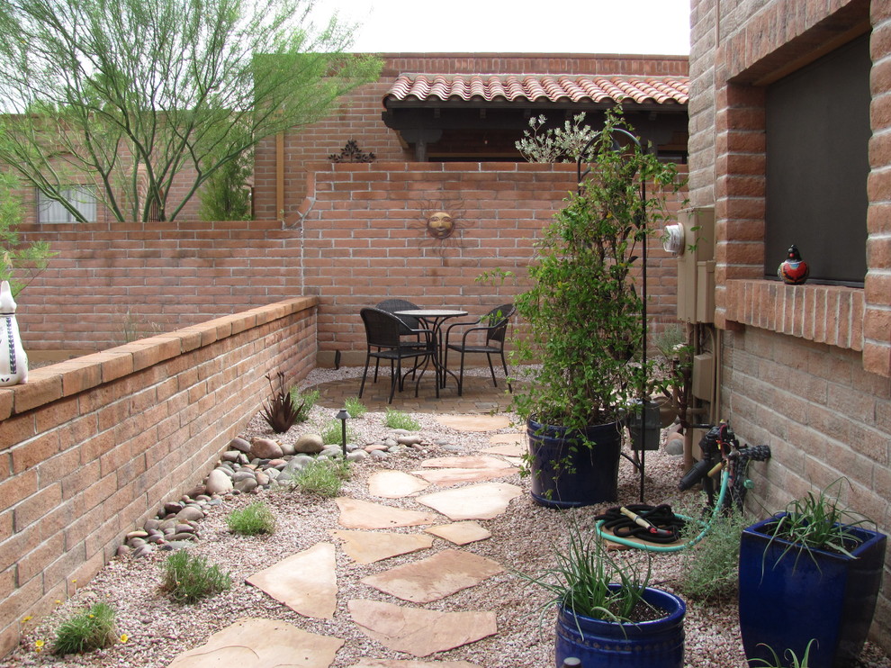 Kleiner Mediterraner Garten im Innenhof im Frühling mit direkter Sonneneinstrahlung und Betonboden in Phoenix