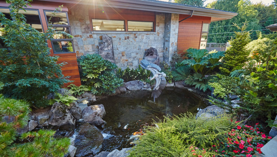 Modelo de jardín contemporáneo grande en patio lateral con fuente