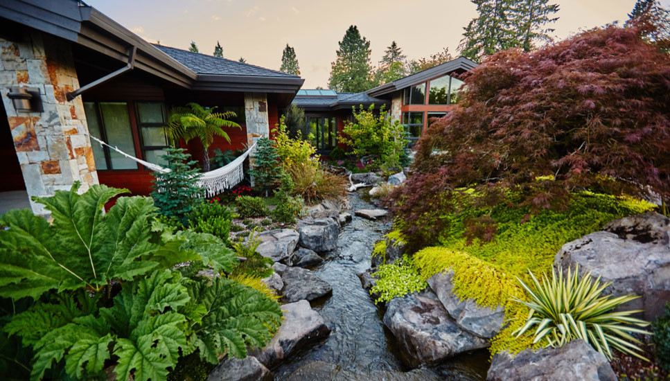 Photo of a large contemporary backyard water fountain landscape in Portland.