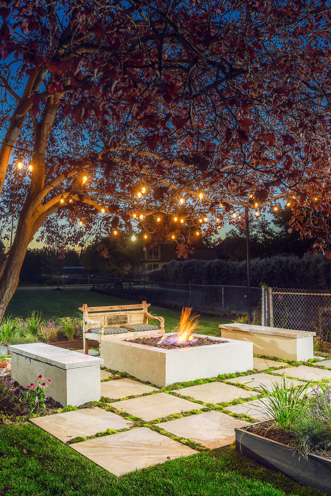 Modelo de jardín clásico renovado en patio trasero con brasero, exposición total al sol y adoquines de hormigón