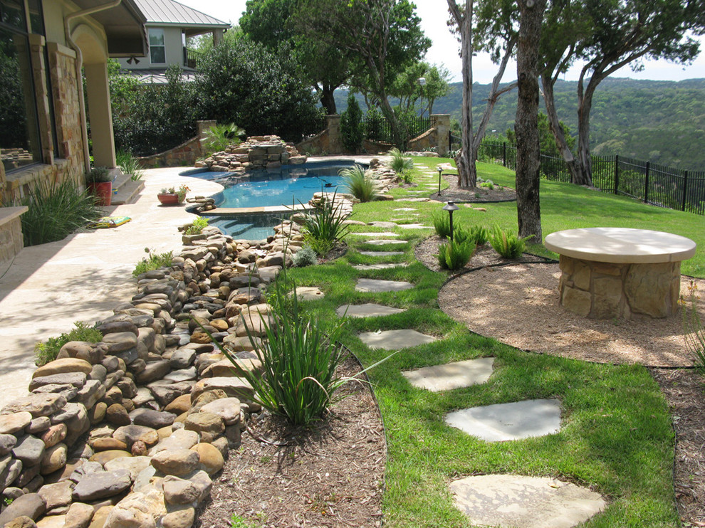 Ejemplo de jardín mediterráneo grande en patio trasero con brasero, exposición parcial al sol y adoquines de piedra natural
