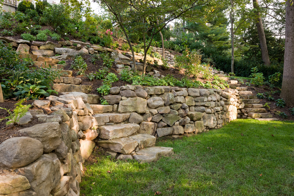 Idee per un giardino formale tradizionale dietro casa con pavimentazioni in pietra naturale
