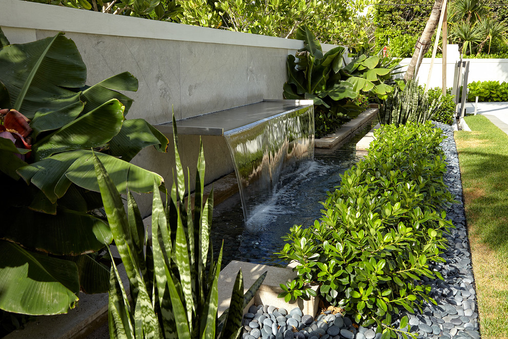 Diseño de jardín contemporáneo grande en patio trasero con jardín francés, fuente y exposición parcial al sol