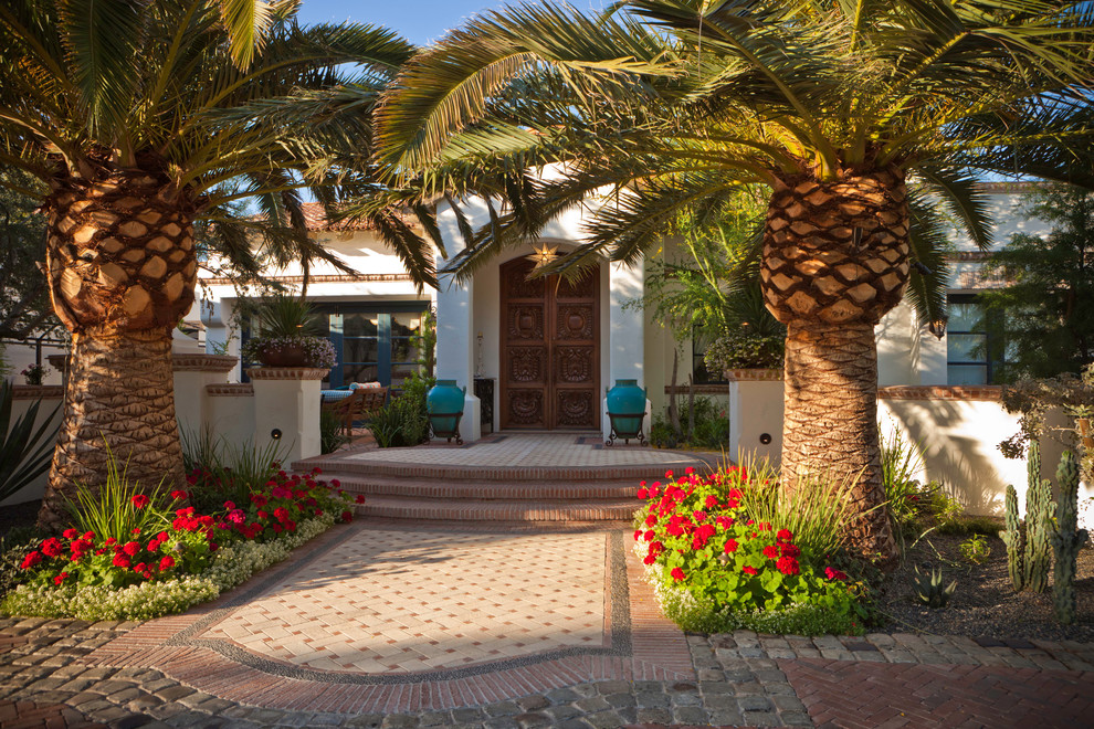 Immagine di un giardino mediterraneo dietro casa con un giardino in vaso e pavimentazioni in mattoni