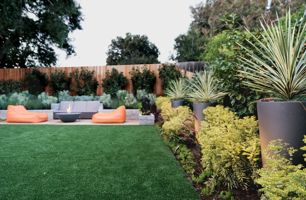 Foto di un giardino minimalista esposto in pieno sole di medie dimensioni e dietro casa con pavimentazioni in cemento e un focolare