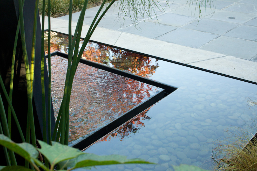 Immagine di un giardino minimalista dietro casa con fontane e pavimentazioni in pietra naturale