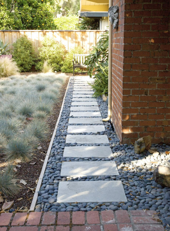 Immagine di un giardino minimalista esposto a mezz'ombra di medie dimensioni e dietro casa con pavimentazioni in pietra naturale