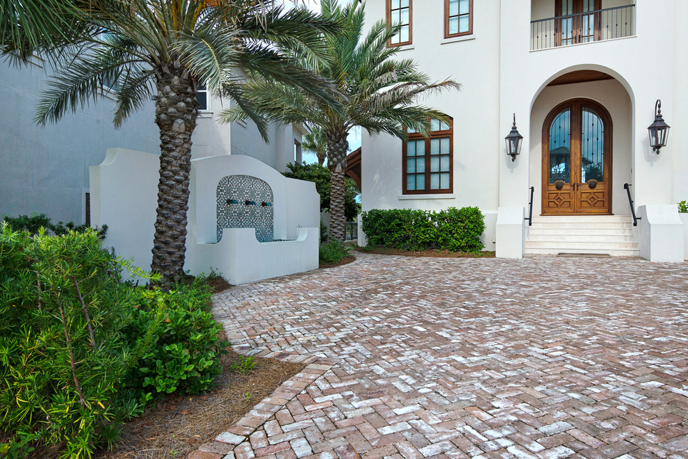 Идея дизайна: большой садовый фонтан на переднем дворе в средиземноморском стиле с подъездной дорогой, полуденной тенью и мощением клинкерной брусчаткой