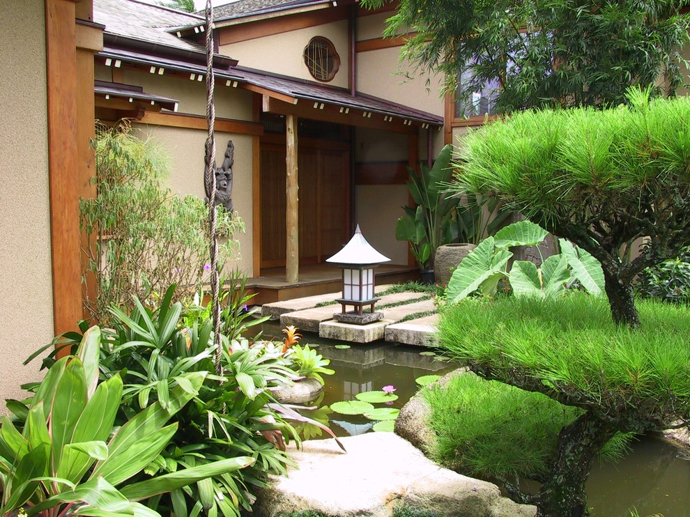 Inspiration för mycket stora asiatiska formella trädgårdar i full sol framför huset på vinteren, med en damm och naturstensplattor