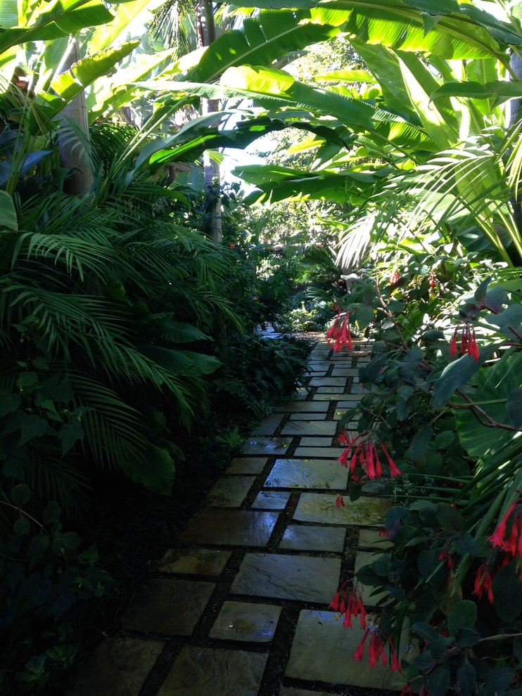 Foto di un ampio vialetto d'ingresso tropicale esposto in pieno sole in cortile con pavimentazioni in pietra naturale