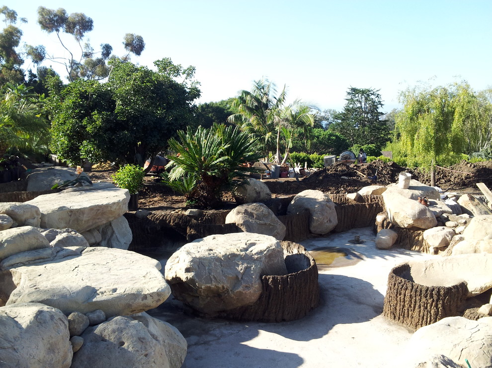 Idéer för att renovera en mycket stor tropisk bakgård i full sol, med en fontän