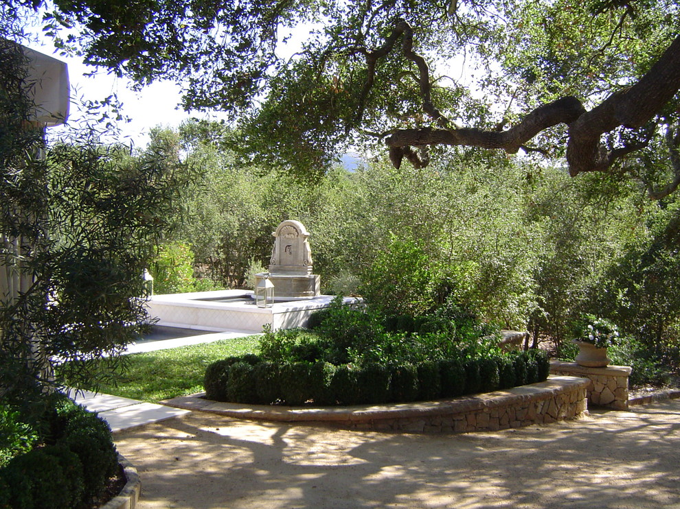 Großer, Schattiger Mediterraner Garten hinter dem Haus mit Wasserspiel und Natursteinplatten in Los Angeles