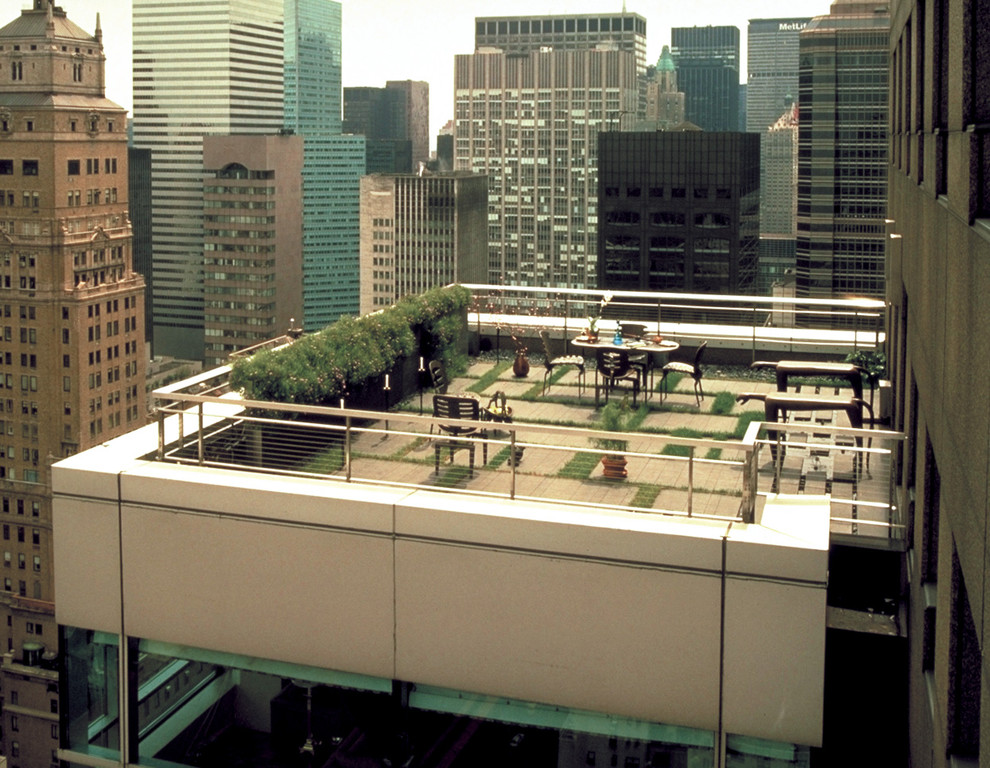 Photo of a mid-sized contemporary full sun rooftop concrete paver water fountain landscape in New York.