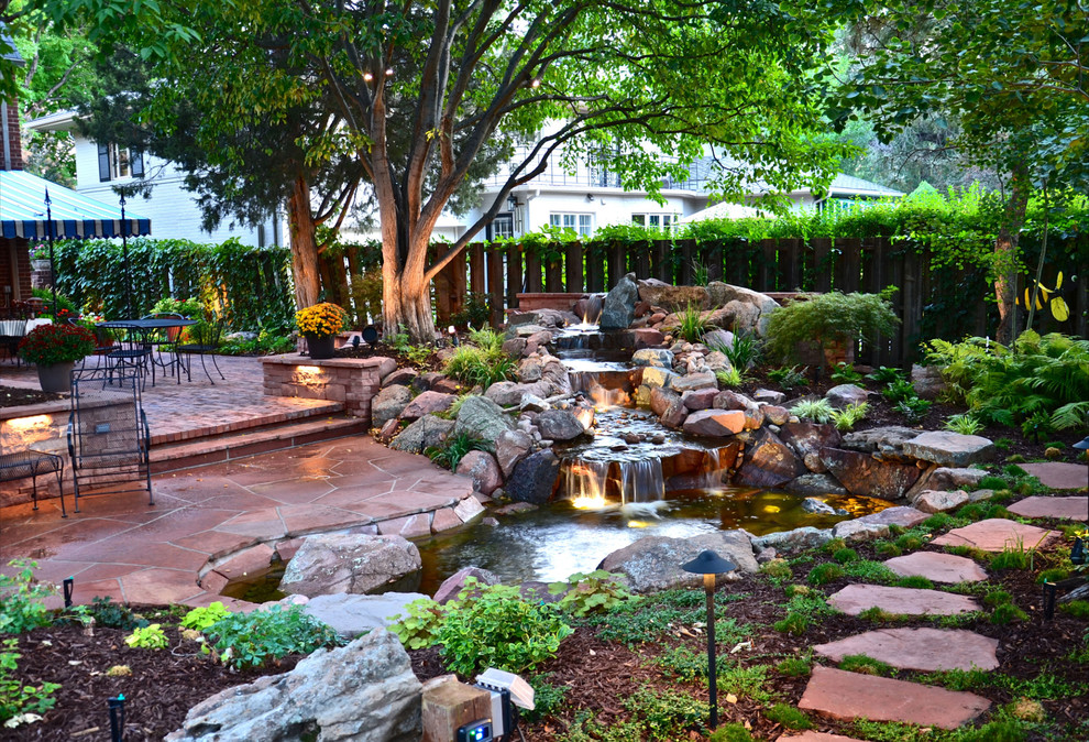Идея дизайна: участок и сад на заднем дворе в классическом стиле с покрытием из каменной брусчатки и водопадом