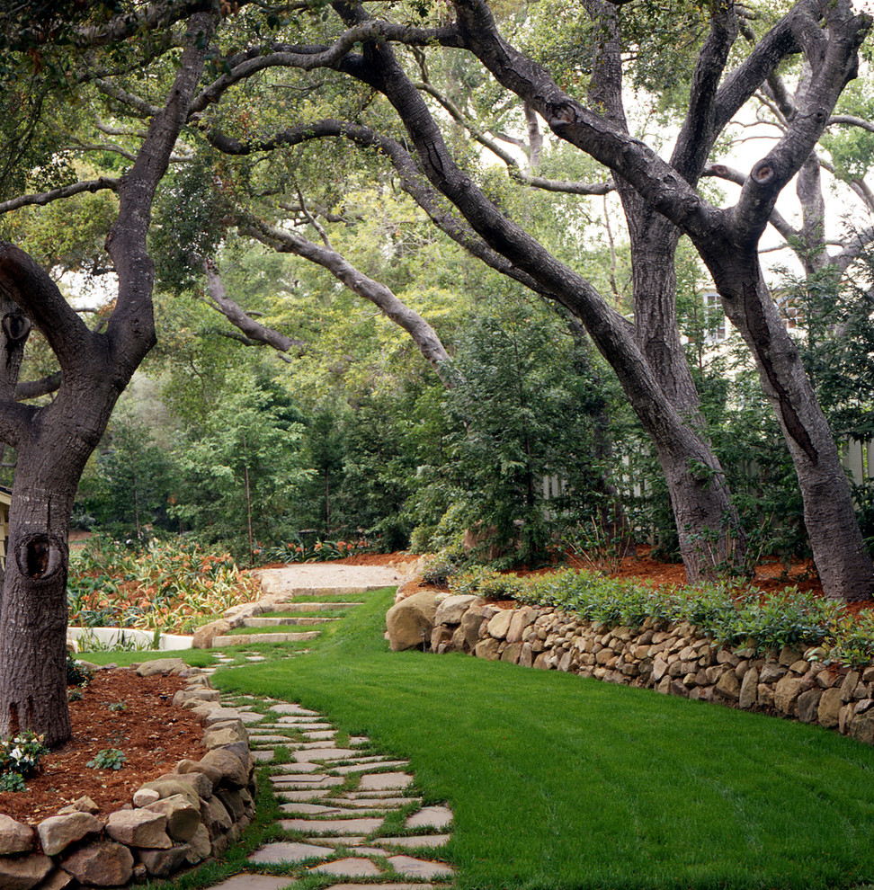 Immagine di un giardino chic in ombra con pavimentazioni in pietra naturale e scale