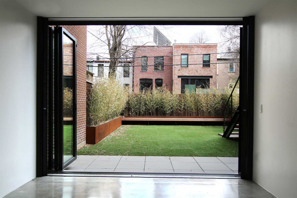 Ispirazione per un piccolo giardino minimalista esposto a mezz'ombra dietro casa con pavimentazioni in cemento