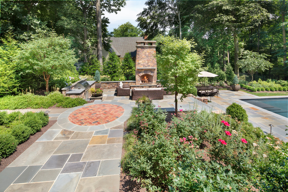 Cette image montre un grand jardin arrière traditionnel avec un foyer extérieur, une exposition partiellement ombragée et des pavés en pierre naturelle.