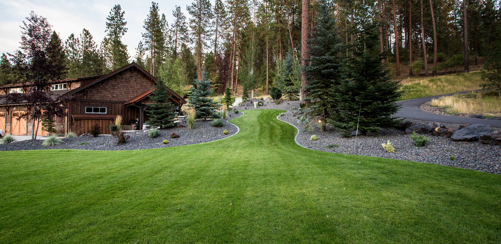 Photo of an expansive rustic sloped garden in Seattle with a retaining wall and concrete paving.