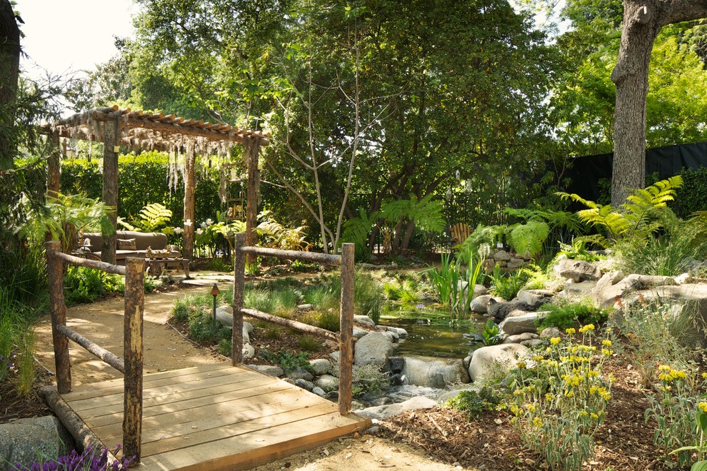 This is an example of a contemporary garden in Los Angeles with a water feature.