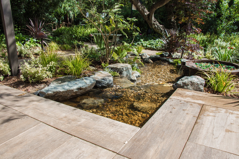 Inspiration for a large contemporary drought-tolerant and partial sun backyard concrete paver pond in Los Angeles for summer.