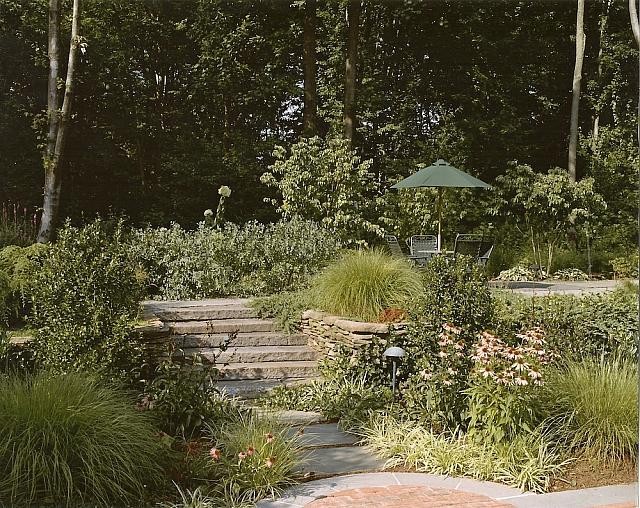 Diseño de jardín clásico grande en patio trasero con adoquines de ladrillo