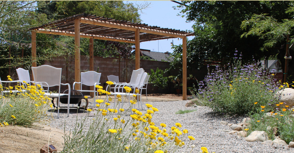 Ejemplo de jardín de secano clásico de tamaño medio en verano en patio trasero con exposición total al sol y adoquines de piedra natural