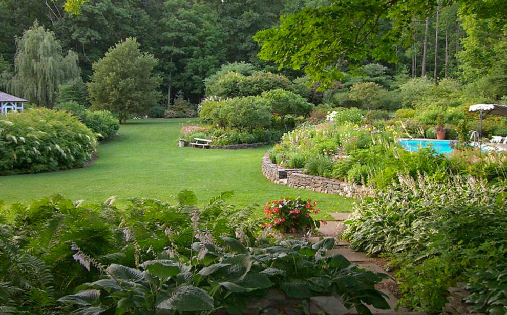 Idées déco pour un très grand jardin arrière classique avec une exposition ensoleillée et des pavés en béton.