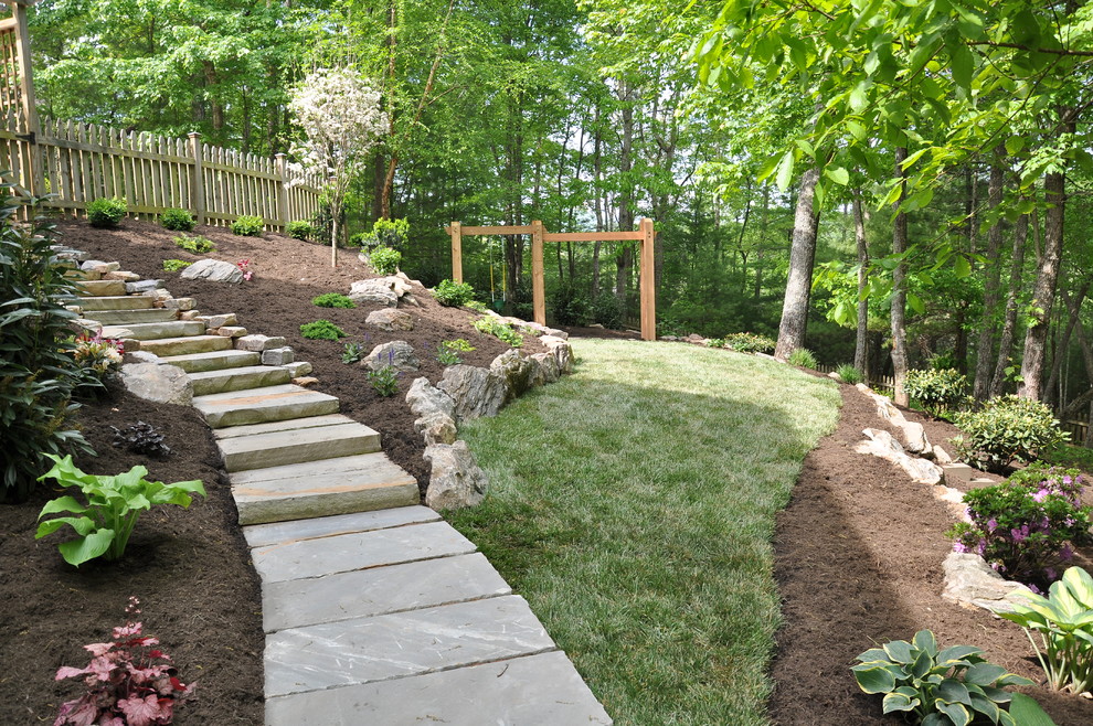 Photo of a mid-sized traditional partial sun side yard stone garden path in Other.