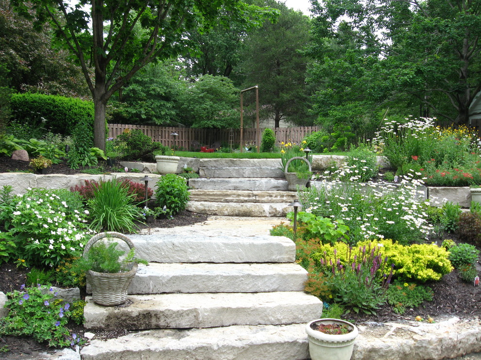 Foto di un grande giardino tradizionale esposto in pieno sole dietro casa con un ingresso o sentiero e pavimentazioni in pietra naturale